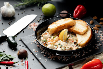 Prawns Shrimps roasted in garlic butter with lemon and parsley on wooden background. Healthy food.