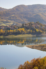 Fototapeta na wymiar A foggy day at Lake Turano. The colors of autumn in Castel di Tora in Rieti