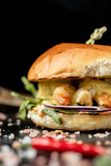 Healthy Tasty prawn grilled burger with pea shoots and sweet chilli dip served on wooden board 