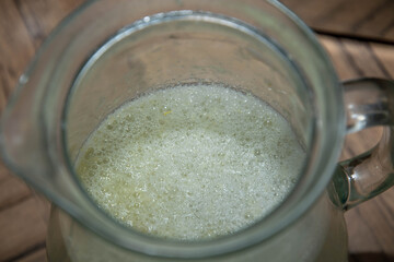 fresh lemon water with foam in a carafe