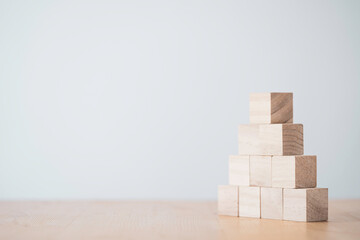 stacking blank wooden cubes on table with copy space for input wording and infographic icon.