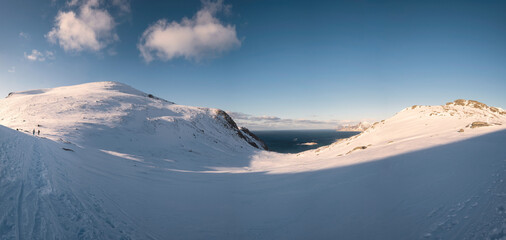 Panorama of snow mountain range with sunshine and blue sky on winter at Lofoten Islands