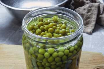 A glass jar with canned peas in the home kitchen.