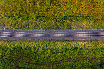 railway track line through autumn forest, view from above