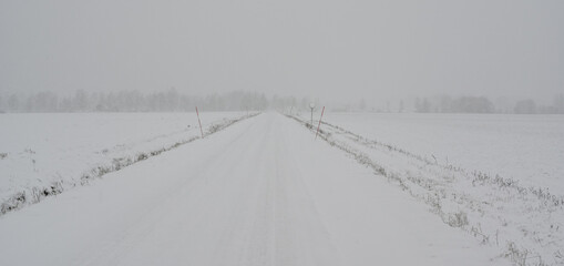 straight winter road covered in snow in Sweden