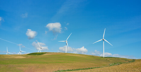 Windmill turbines across picturesque landscape. Energy and ecology concept. Renewable energy
