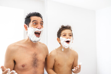 Funny father and son shaving in the bathroom