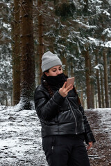 Fototapeta na wymiar young woman enjoying the snow in a forest in Denmark using warm clothes