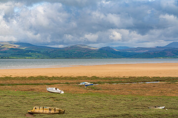 Boats in the grass, with clouds over the Lake District National Park in the background, seen in...