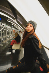 Mujer adolescente sonriendo y feliz en el anden de estación de metro o ferrocarril transporte público