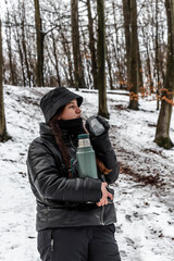 Fototapeta na wymiar young woman enjoying the snow in a forest in Denmark using warm clothes