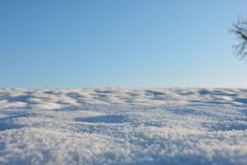 Close up of a snow field with blue sky on the horizon