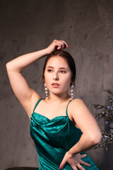 Fototapeta premium sexy attractive brunette woman in elegant green aquamarine dress in a loft cafe. beautiful sensual girl