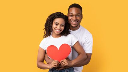 Loving African Couple Hugging Holding Heart Over Yellow Background, Panorama