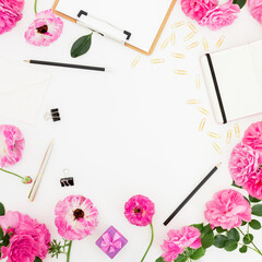 Stylish home workspace with clipboard, notebook, pink flowers and accessories on white background. Flat lay