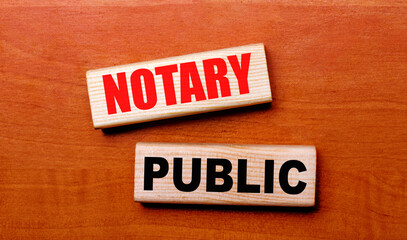 On a wooden table are two wooden blocks with the text NOTARY PUBLIC