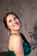 Fototapeta premium sexy attractive brunette woman in elegant green aquamarine dress in a loft cafe. beautiful sensual girl