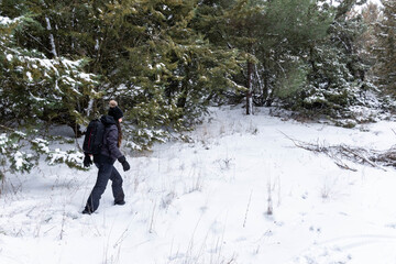 Woman dressed in black walking in the middle of a snow-covered forest Risk sport.