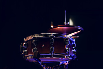 Naklejka premium Snare drum and drumsticks close up in dark.