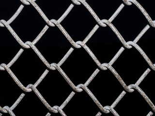 Full frame view of wire fence with a black background