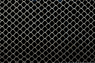Full frame view of wire fence with a black background