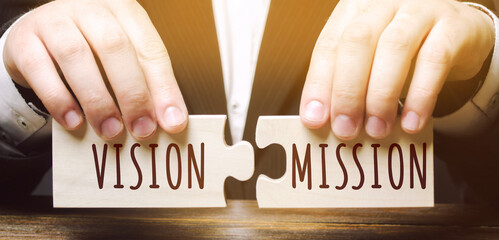 Businessman connects wooden puzzles with the words Vision Mission. Concept for business ideas and...