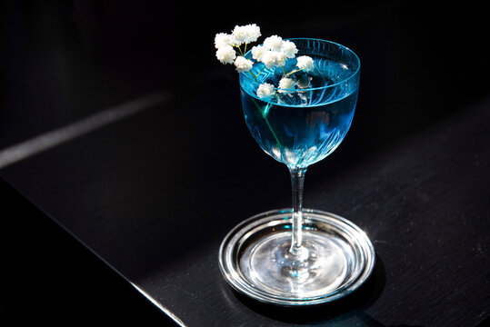 Blue curaçao cocktail garnished with white flowers