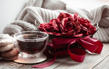 Cozy home composition love is for Valentine's Day with decorative elements and cup of tea.