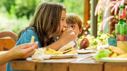 Child eating a hamburger with french fries