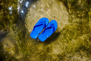 Blue flip flops stay on the water surface