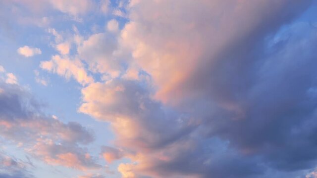 Timelapse of clouds only in the sky, at sunset, with tints of yellow, orange, pink, purple.