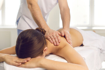 Fototapeta na wymiar Woman patient getting back massage from professional masseur