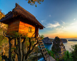 Beautiful sunrise at the famous tourist location the Nusa Penida tree house overlooking the Thousand Islands viewpoint near Bali, Indonesia