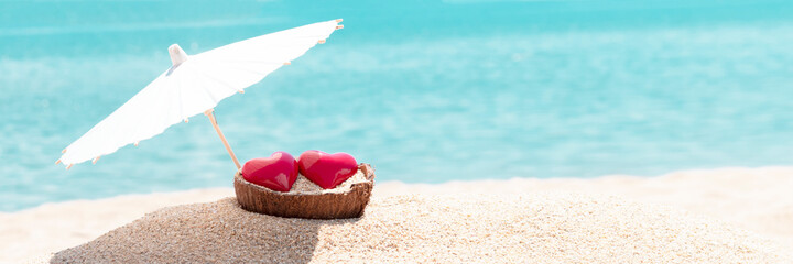 Valentines day concept. Two hearts - symbol of love couple on sand paradise tropical beach under...