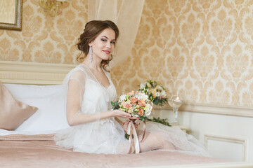 Pretty young Bride.Brown-haired woman with classic wedding hair-style. Boudoir morning of the bride. 