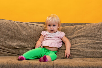 Fototapeta premium A business child is sitting on the couch and watching TV.