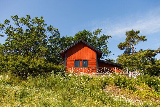 Red summer garden cottage in Sweeden. Traditional Sweden wooden old house. Life on the one of Sweeden islands