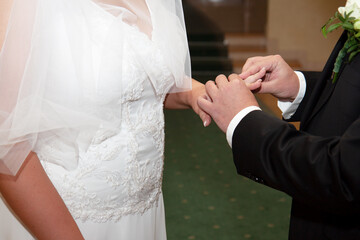 Bride's hand with a wedding ring near the groom