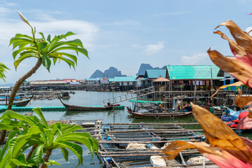 Koh Panyee floating fishermans village in Phang Nga bay national park with fish growing nets constructions in the water and colorful roof buildings © Rytis
