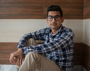 Fototapeta premium Indian boy looking at camera wearing checked blue shirt and cotton pant