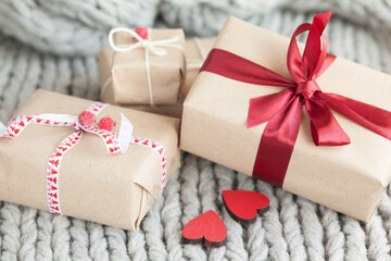 Gift boxes with ribbons on a handmade knitted cozy background. Valentine's Day presents. Happy Birthday. Love consept.

