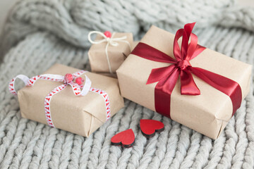 Gift boxes with ribbons on a handmade knitted cozy background. Valentine's Day presents. Happy Birthday. Love consept.

