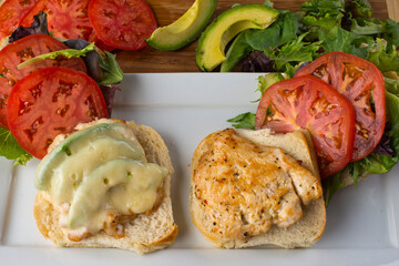 Chicken tender sandwich. Traditional classic american restaurant favorite menu item. Crispy chicken tenders served with bacon lettuce tomato onion and guacamole on a toasted bun.