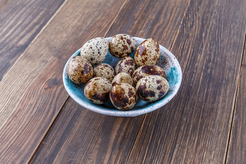 Quail eggs on the wooden plate. Quail eggs can be consumed by frying or boiling. In Indonesia quail eggs called telur puyuh.