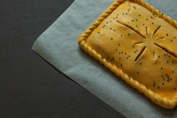 Semi-finished products. frozen, closed pie with filling for quick cooking at home, on baking paper.