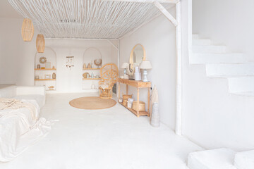 Cozy interior of a bright Balinese-style apartment with white walls, bamboo chair, big white sofa and decorations © 4595886