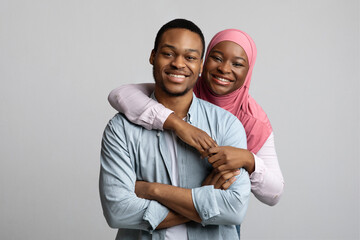 Portrait of loving african american muslim couple posing on grey