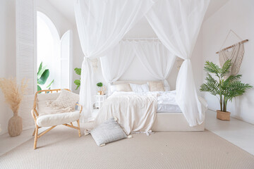 Cozy interior of a bright Balinese-style apartment with white walls, bamboo furniture. bed room with night lights, bed with balanchin and large windows © 4595886