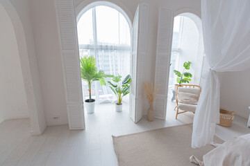Cozy interior of a bright Balinese-style apartment with white walls, bamboo furniture. bed room with night lights, bed with balanchin and large windows © 4595886