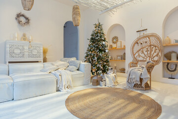 Cozy interior of a bright Balinese-style apartment with completely white walls, wicker furniture. sitting room full of day light decorated with Christmas tree